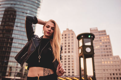 Portrait of beautiful woman standing against buildings