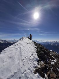 People on snowcapped mountain against sky