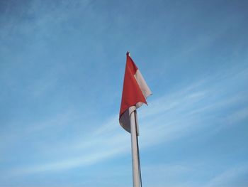 Low angle view of flag against blue sky