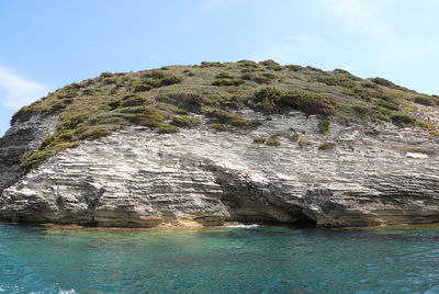 Rock formation in sea against sky