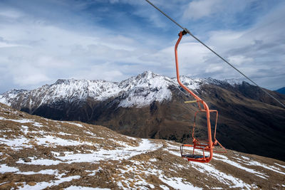 Mountain landscape with a chair of a single-seat cable car for lifting tourists, skiers and climbers