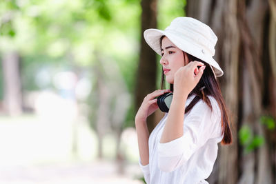 Portrait of young woman wearing hat standing outdoors