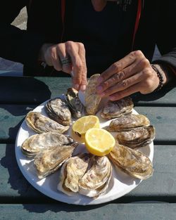 Midsection of man having oyster at table