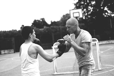 Young male trainer teaching boxing to boy