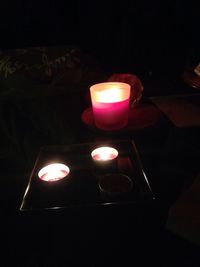 Close-up of lit candle in dark room