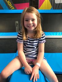 Portrait of smiling girl sitting outdoors