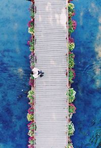 Aerial view of man flying drone over bridge amidst sea