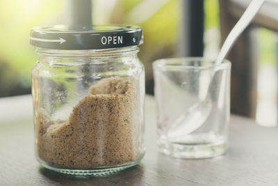 Close-up of brown sugar in jar on wooden table