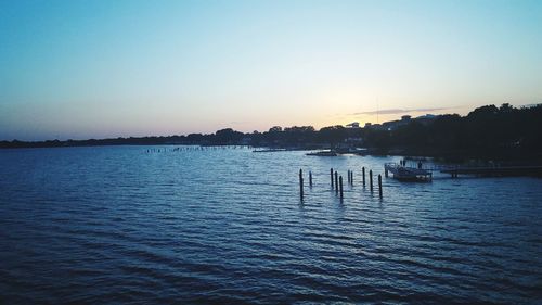 Scenic view of lake against clear sky at sunset