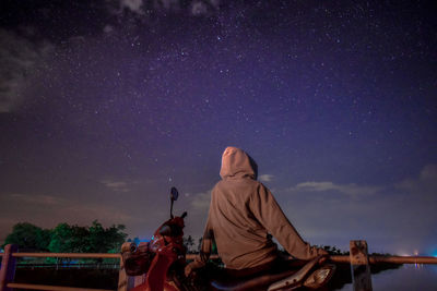 Rear view of people looking at sky at night