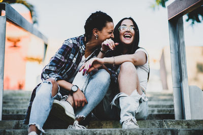 Happy young woman sitting on steps