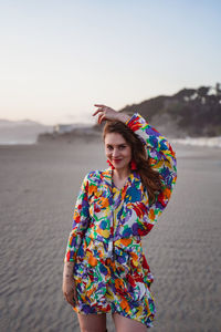 Portrait of beautiful young woman standing on beach