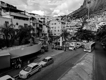 Cars on road by buildings in city against sky