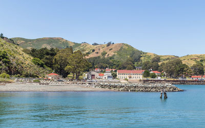 Scenic view of sea by buildings against clear sky