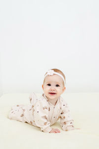 Portrait of cute baby boy lying on bed at home