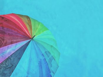 Low angle view of multi colored umbrella against clear blue sky