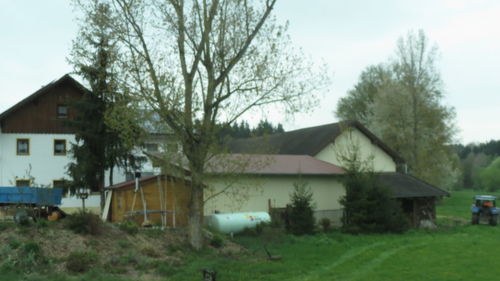 Houses by barn against sky