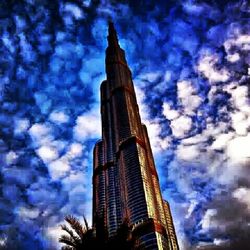 Low angle view of modern building against cloudy sky