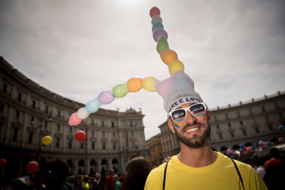 Portrait of people with balloons against building