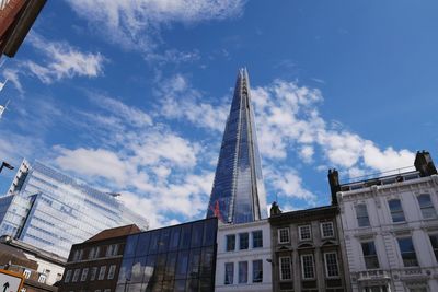 Low angle view of buildings against cloudy sky