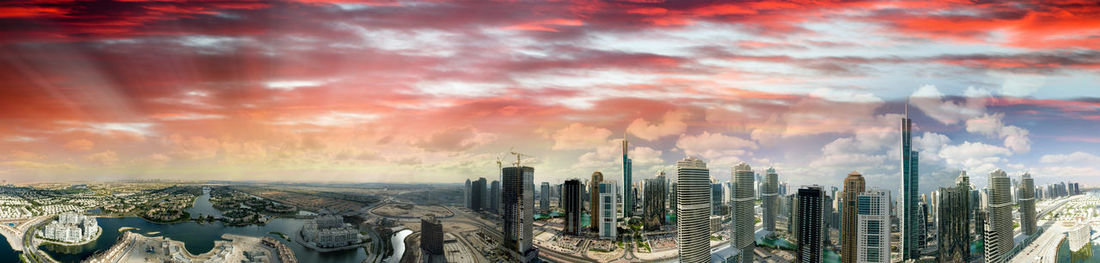 Panoramic view of buildings against cloudy sky