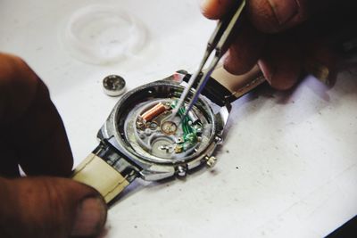 Hands repairing wristwatch