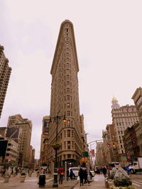 People walking in city against clear sky