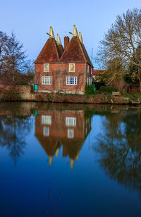 Reflection of building on lake against sky