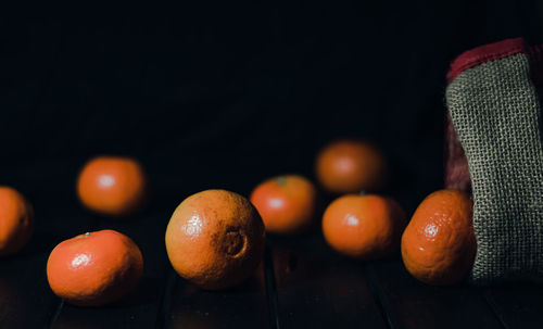 Close-up of oranges on table against black background