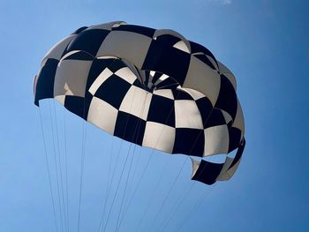 Low angle view of parachute against blue sky