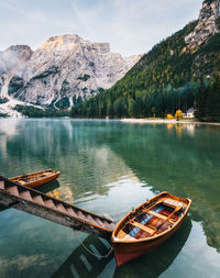 Boats moored on lake against mountains