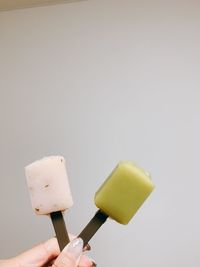 Hand holding ice cream cone against white background