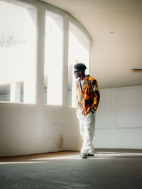 Side view of man standing against wall