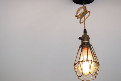 Low angle view of illuminated light bulbs hanging from ceiling