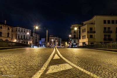 Surface level of road against buildings at night