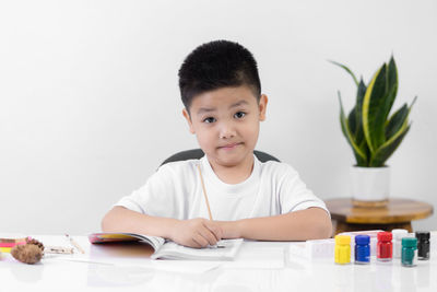 Portrait of cute boy sitting on table