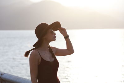 Full length of young woman at beach against sky