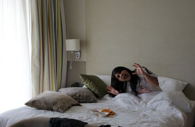 Young woman lying on bed at home