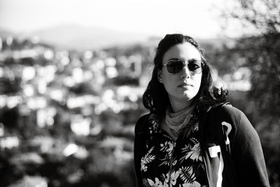 Portrait of young woman wearing sunglasses standing outdoors