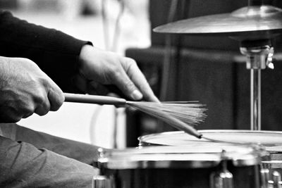 Midsection of man playing drums