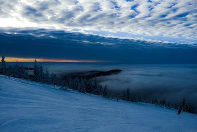 Scenic view of snow covered land against sky