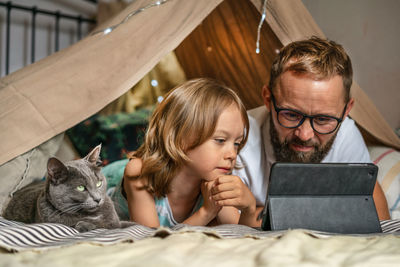 Portrait of smiling woman using laptop while sitting on bed at home