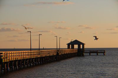 Silhouette pier on sea against sky during sunset