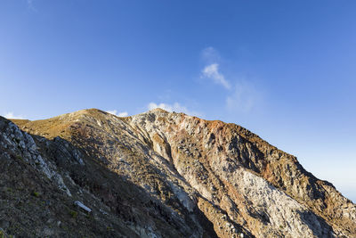 Low angle view of mountain against clear blue sky