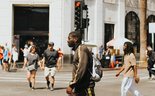 Group of people walking on road in city