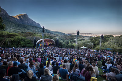 Crowd on mountain against clear sky