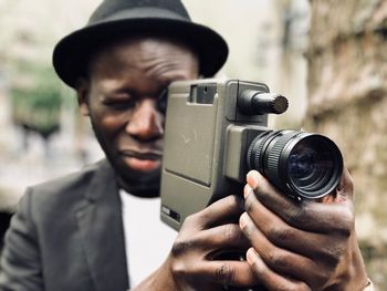 Close-up of man photographing through camera