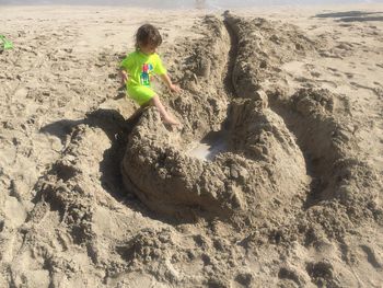 Child playing on sand at beach