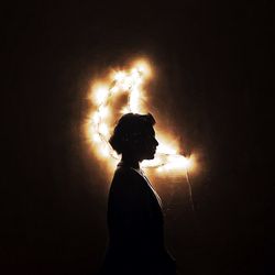 Rear view of silhouette man with arms outstretched