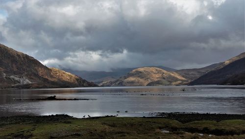 Scenic view of lake and mountains against sky